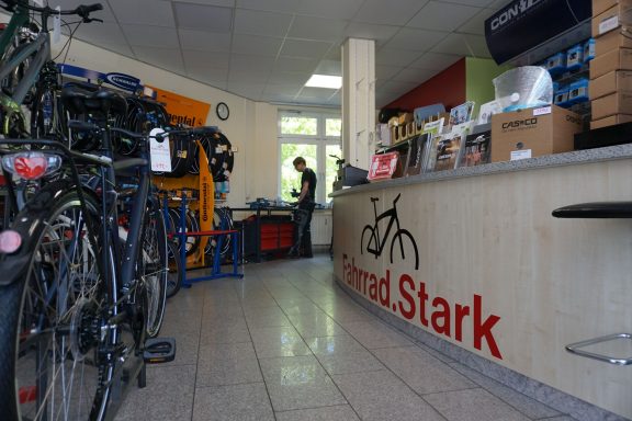 Links sind Fahrräder zu sehen, recht ist der Ahornfarbene Tresen mit dem Schriftzug Fahrrad.Stark zu sehen. 