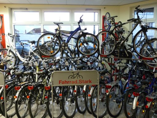 Im Fahrradladen Fahrrad.Stark gibt es eine große Auswahl an Fahrrädern. Sie sind vor einem Schaufenster arrangiert. 