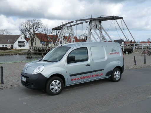 Ein Renault Kangoo Z.E. mit dem Schriftzug Fahrrad.Stark vor der historischen Brücke in Eldena